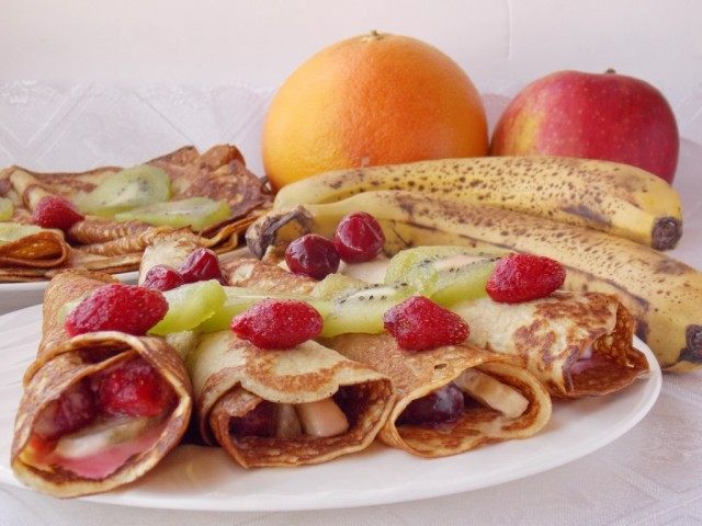 Выкладываем завернутые блинчики с фруктами на тарелку украсив фруктами Выкладываем завернутые блинчики с фруктами на тарелку украсив фруктами