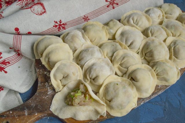 Лепим пельмени и укладываем на доску, посыпанную мукой Лепим пельмени и укладываем на доску, посыпанную мукой