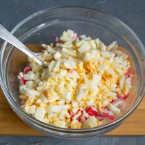 Отвариваем вкрутую куриные яйца, охлаждаем, измельчаем и добавляем в салатницу Отвариваем вкрутую куриные яйца, охлаждаем, измельчаем и добавляем в салатницу