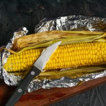 Разворачиваем фольгу и смазываем готовую кукурузу сливочным маслом Разворачиваем фольгу и смазываем готовую кукурузу сливочным маслом