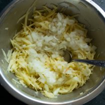 Отжимаем тёртый картофель, добавляем нарезанный лук Отжимаем тёртый картофель, добавляем нарезанный лук
